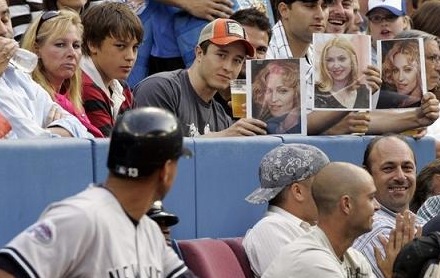Fans hold Madonna photos as New York Yankees' Alex Rodriguez waits to bat against the Blue Jays in Toronto